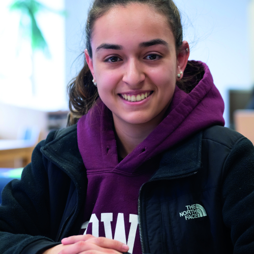 Female Student in MassBay Library, smiling at camera
